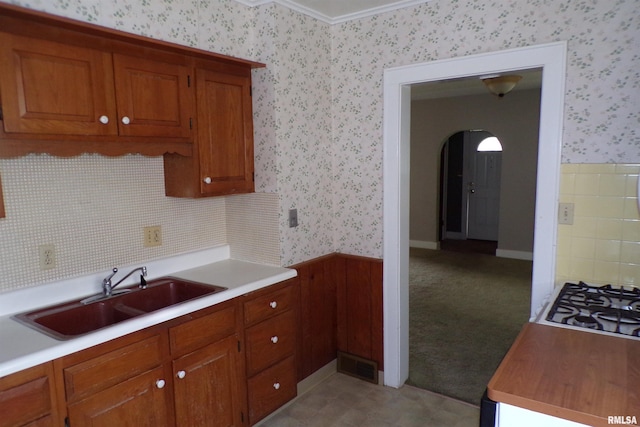 kitchen featuring white gas cooktop, sink, light carpet, and ornamental molding