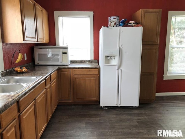 2307 Farnam St, Davenport, IA 52803 - kitchen with white appliances, dark wood finished floors, dark countertops, and brown cabinetry