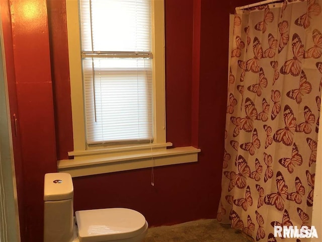 bathroom with curtained shower and toilet