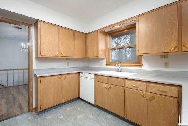 kitchen featuring a sink, visible vents, white dishwasher, and light countertops