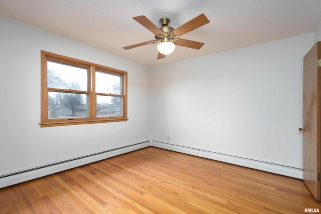 spare room featuring light wood-type flooring, baseboard heating, ceiling fan, and a textured ceiling