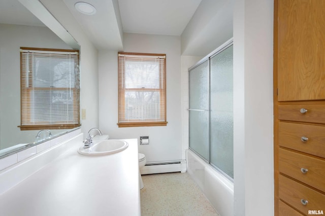 full bathroom featuring vanity, speckled floor, enclosed tub / shower combo, a baseboard radiator, and toilet