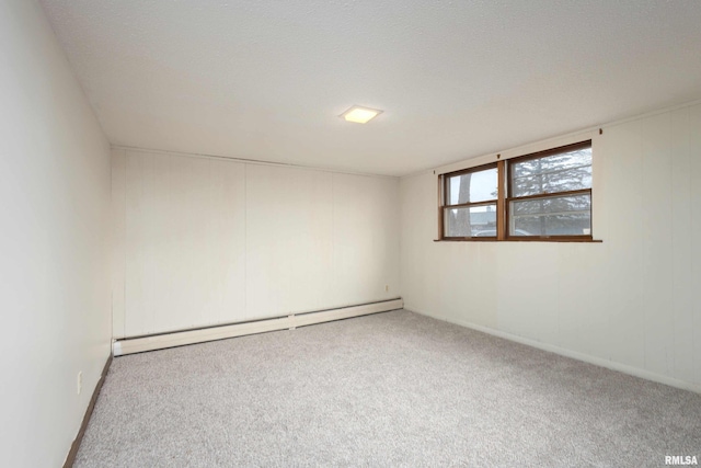 carpeted empty room with a baseboard heating unit and a textured ceiling