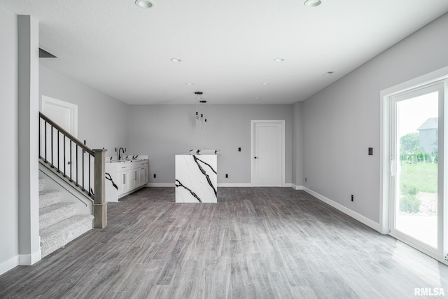 1915 E 59th Ct, Davenport, IA 52807 - unfurnished living room with wood finished floors, stairs, and recessed lighting