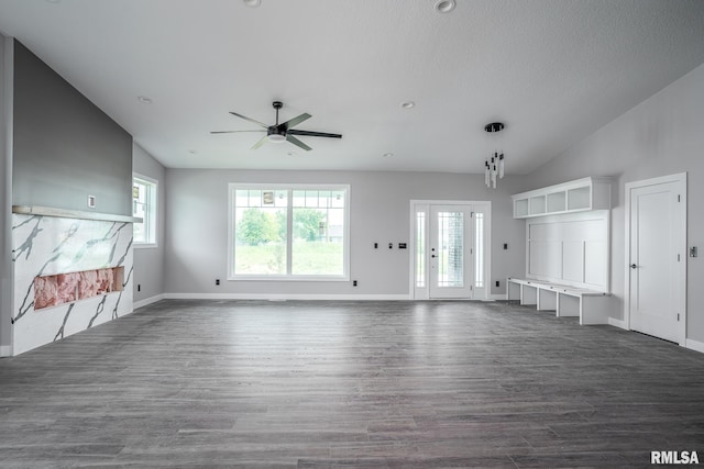 1915 E 59th Ct, Davenport, IA 52807 - unfurnished living room featuring ceiling fan, dark wood-style flooring, lofted ceiling, and a textured ceiling
