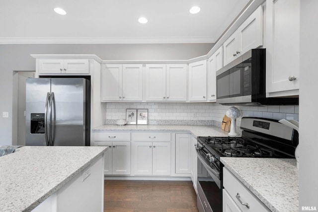 kitchen with white cabinets, light stone countertops, dark wood-type flooring, and appliances with stainless steel finishes