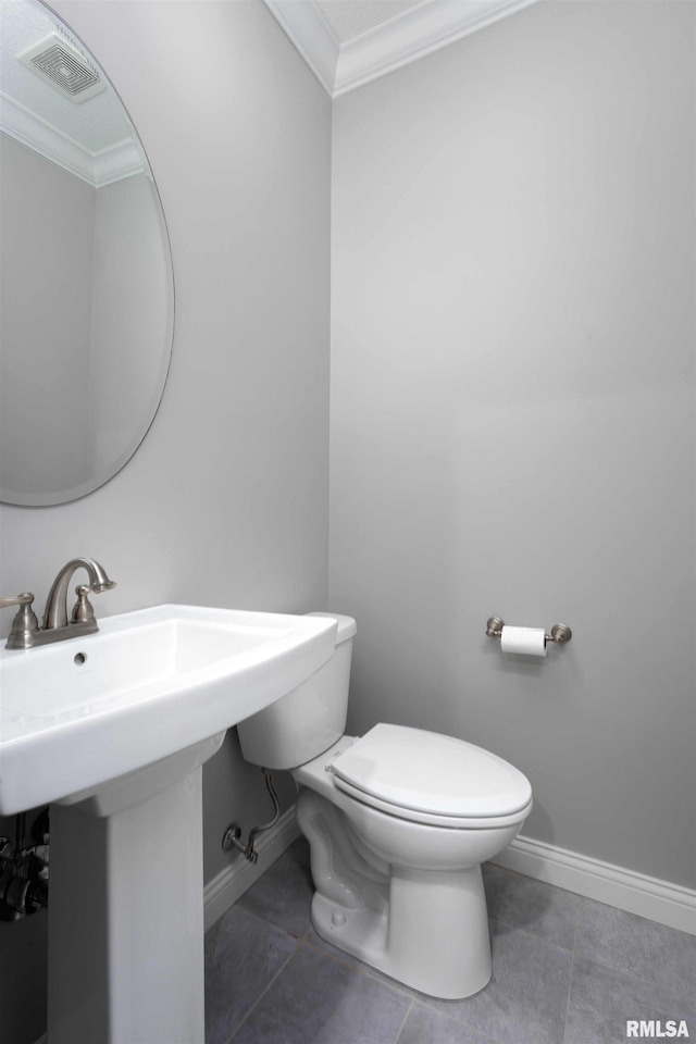 bathroom featuring tile patterned floors, toilet, and ornamental molding