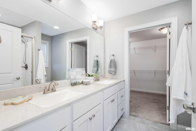 bathroom with tile patterned flooring, a textured ceiling, and vanity