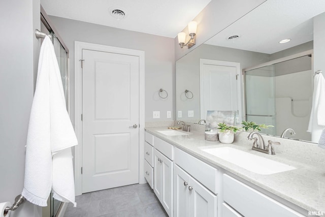 bathroom featuring tile patterned flooring, vanity, and a shower with door