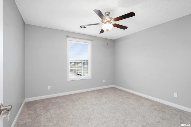 carpeted spare room featuring ceiling fan and a textured ceiling