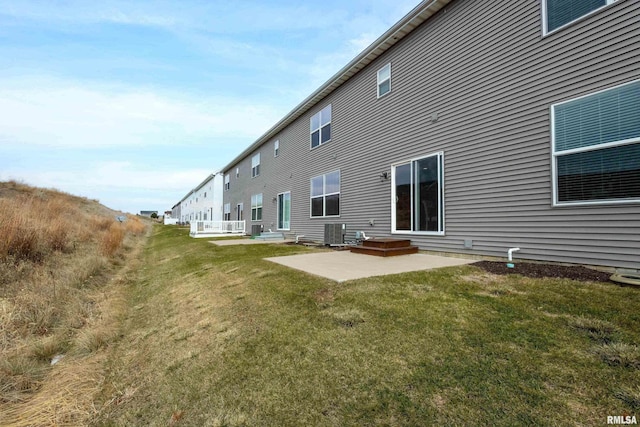 back of property with a lawn, central AC, and a patio