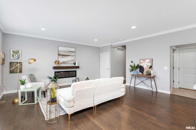 living room featuring dark wood-type flooring, a textured ceiling, and ornamental molding