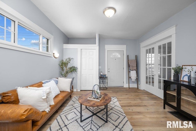 living room with french doors and light hardwood / wood-style floors