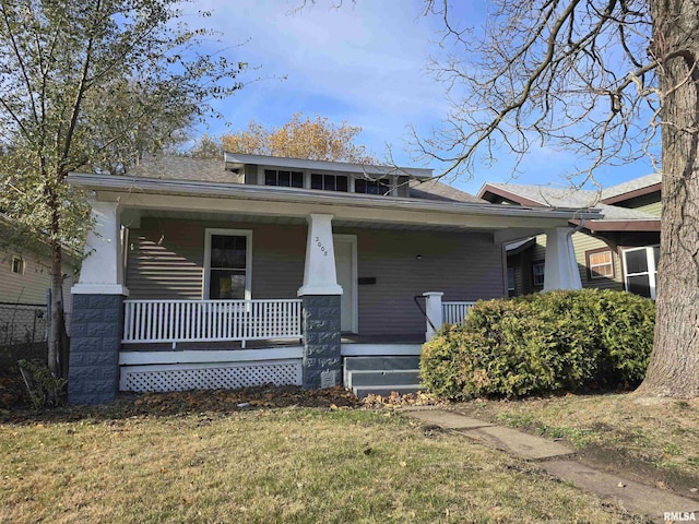 view of front of house with covered porch and a front yard