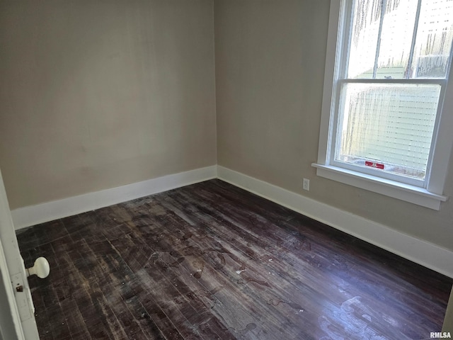 empty room with dark hardwood / wood-style floors and a healthy amount of sunlight