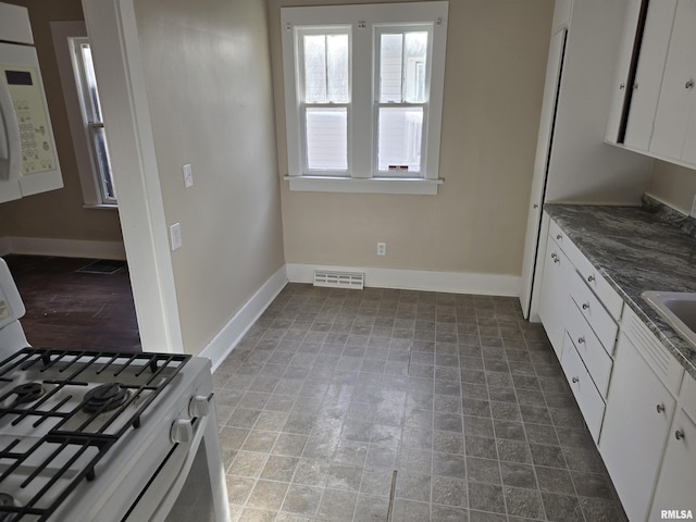 kitchen featuring white cabinets, white appliances, and sink