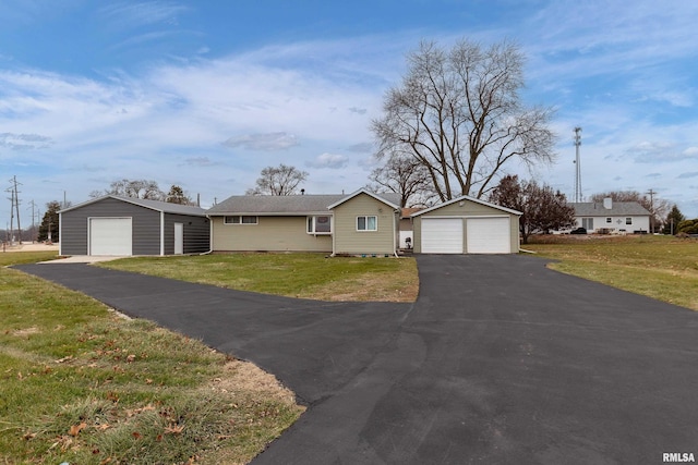 ranch-style house with a front yard, a garage, and an outdoor structure