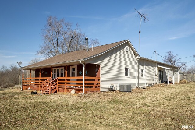 view of front of home featuring cooling unit, a front yard, and a deck