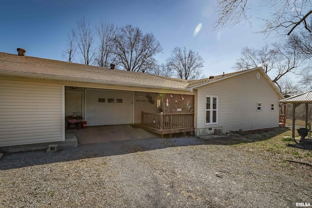 exterior space featuring an attached garage and gravel driveway