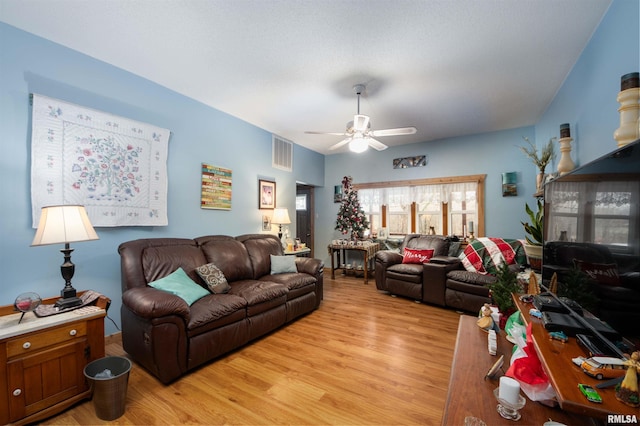 living area with a ceiling fan, visible vents, and light wood finished floors