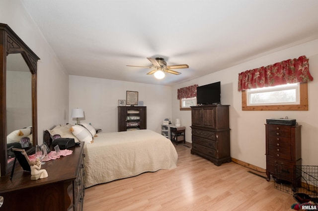 bedroom featuring a ceiling fan, baseboards, and light wood-type flooring