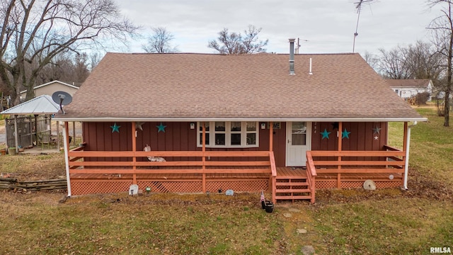 view of front of property with board and batten siding, a shingled roof, and a front lawn