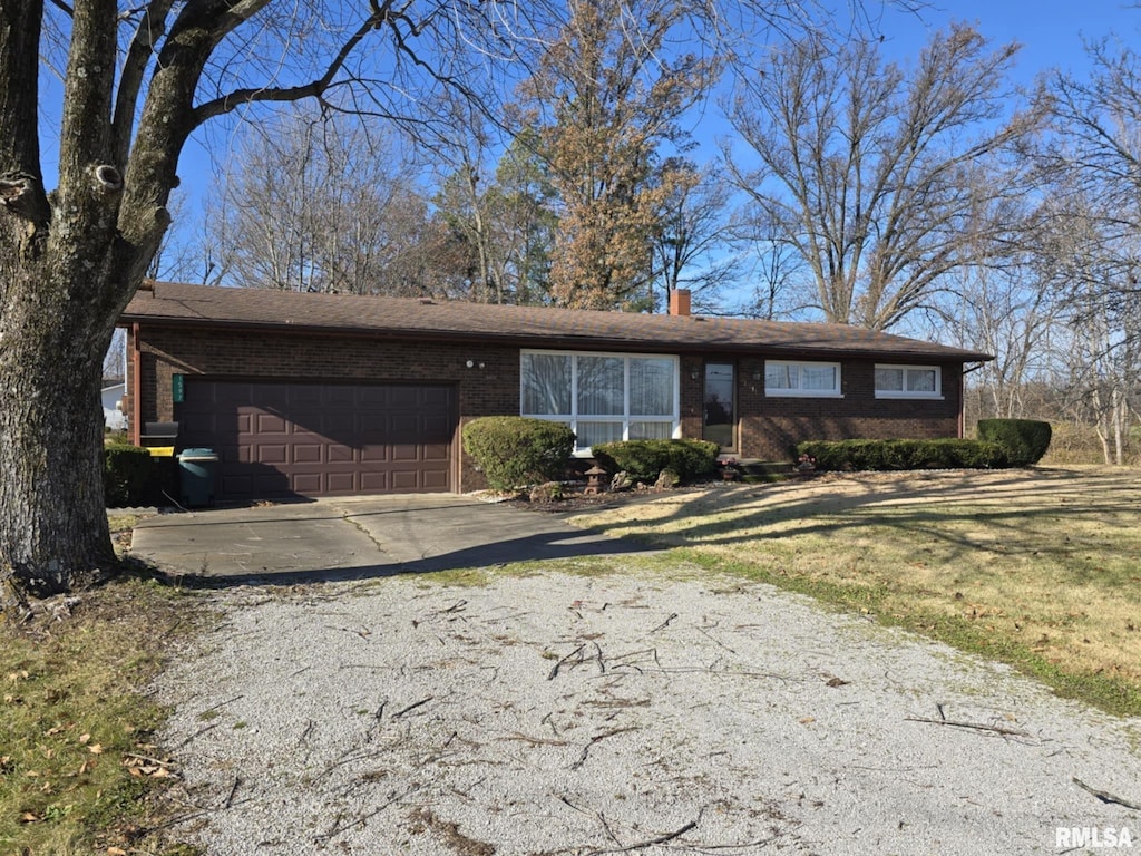 ranch-style home featuring a garage and a front lawn