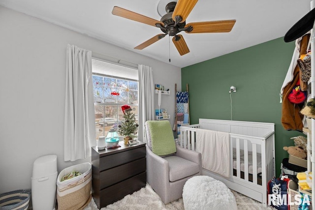 bedroom featuring a crib and ceiling fan