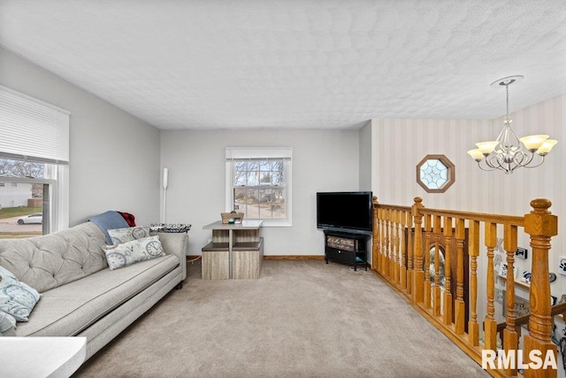 living room featuring an inviting chandelier, a textured ceiling, and carpet floors