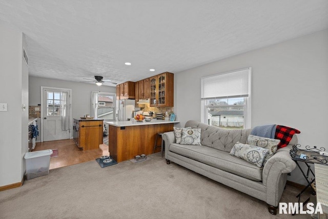 carpeted living room featuring ceiling fan