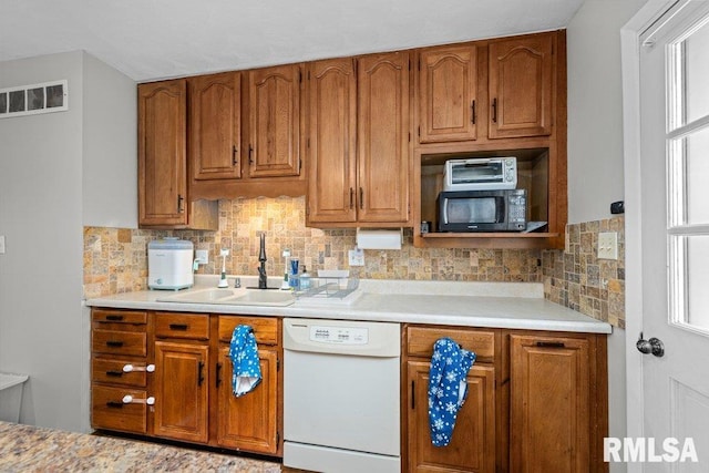 kitchen featuring dishwasher, tasteful backsplash, and sink