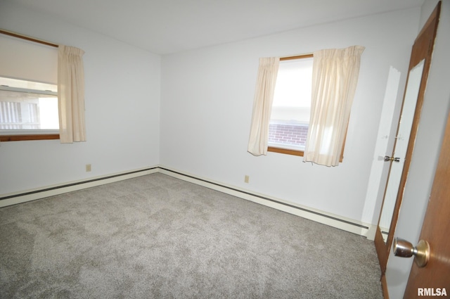 empty room with carpet, plenty of natural light, and a baseboard heating unit