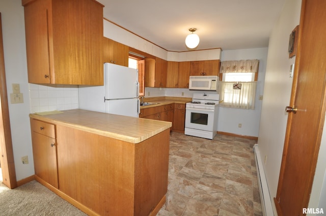 kitchen with white appliances, a baseboard heating unit, sink, decorative backsplash, and kitchen peninsula