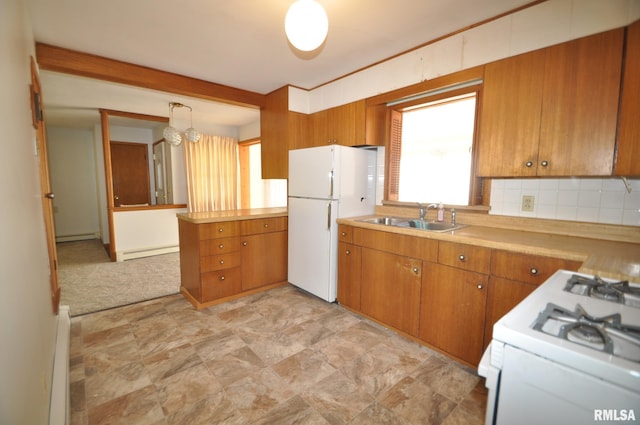 kitchen featuring white appliances, backsplash, sink, hanging light fixtures, and a baseboard radiator