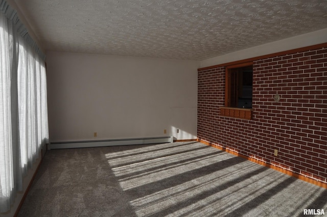 carpeted spare room featuring a textured ceiling, baseboard heating, and brick wall