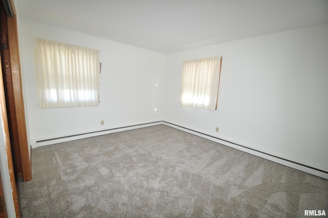 spare room with carpet and a baseboard heating unit