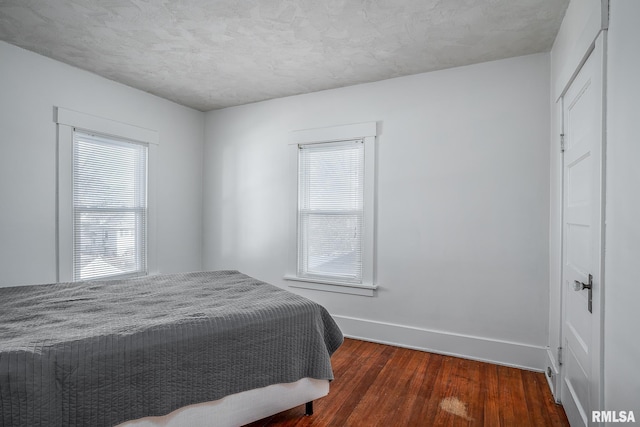 bedroom featuring dark hardwood / wood-style flooring and multiple windows