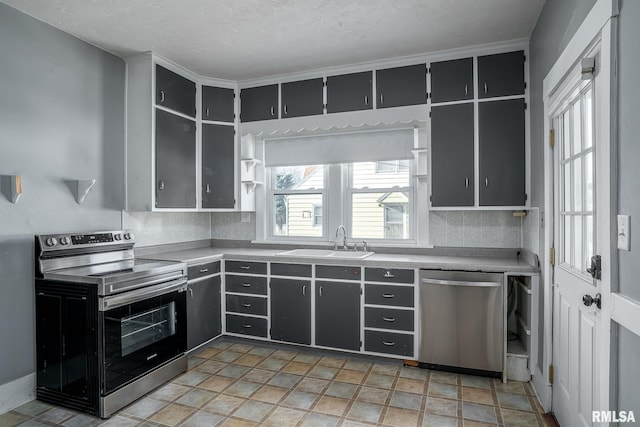 kitchen with a textured ceiling, sink, and stainless steel appliances