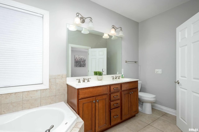 bathroom featuring tile patterned floors, vanity, a relaxing tiled tub, and toilet