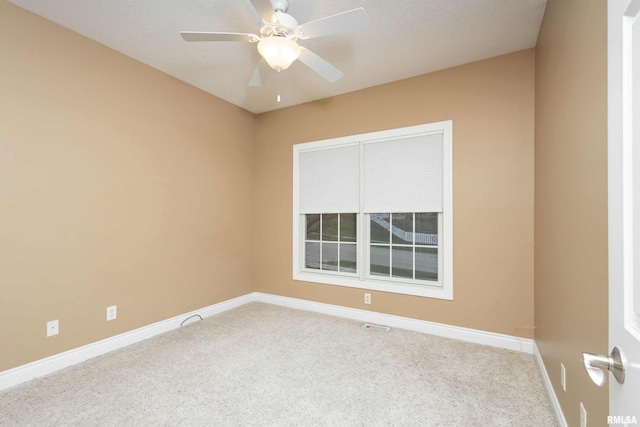 carpeted spare room featuring ceiling fan