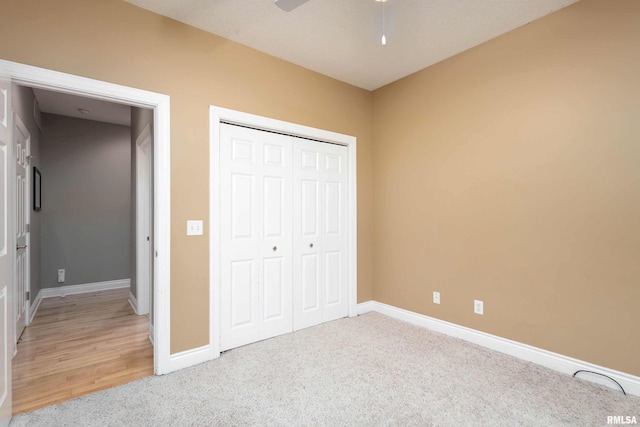 unfurnished bedroom with ceiling fan, a closet, and carpet floors