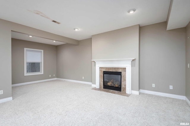 unfurnished living room with a tile fireplace and light carpet