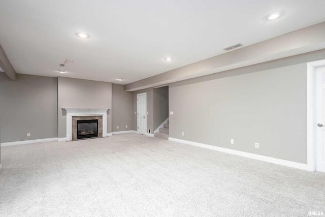 unfurnished living room featuring carpet and a tile fireplace