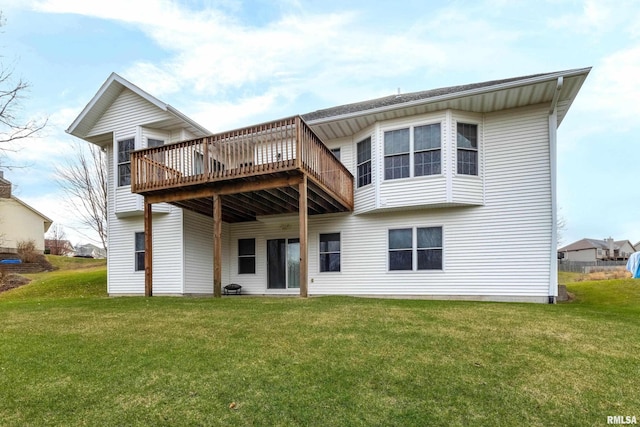 rear view of property featuring a lawn and a wooden deck