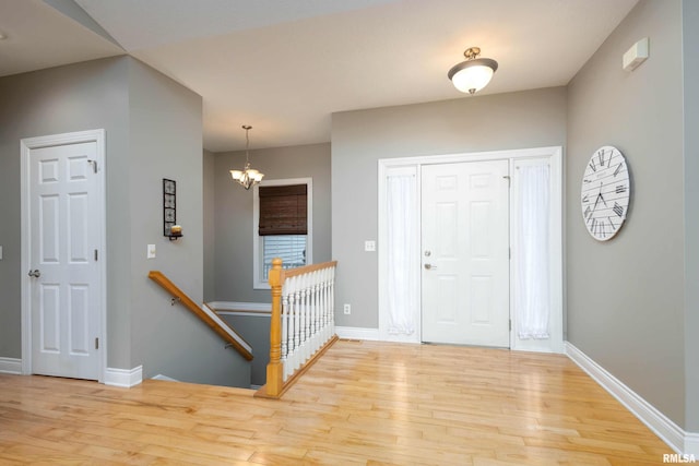 foyer entrance with a chandelier and light hardwood / wood-style floors