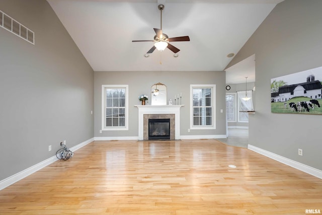 unfurnished living room with ceiling fan, a fireplace, high vaulted ceiling, and light hardwood / wood-style floors