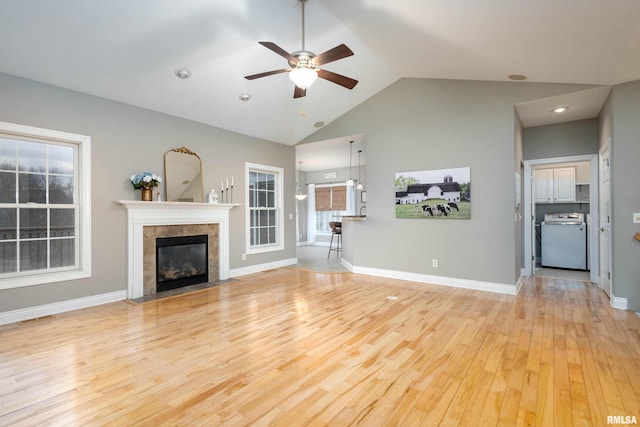 unfurnished living room featuring washer / dryer, light hardwood / wood-style flooring, ceiling fan, and lofted ceiling