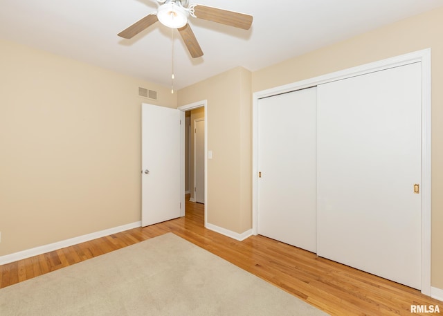 unfurnished bedroom featuring a closet, hardwood / wood-style flooring, and ceiling fan