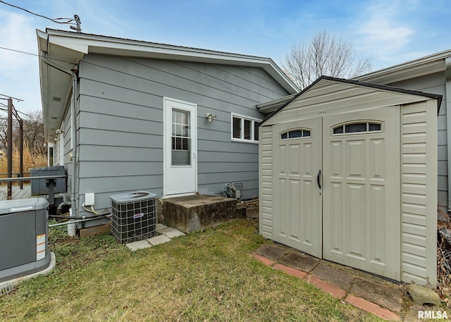 view of outdoor structure with central AC and a lawn