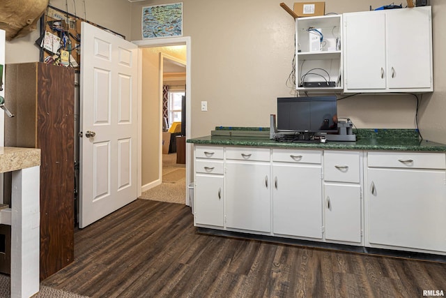 kitchen with dark hardwood / wood-style floors and white cabinetry